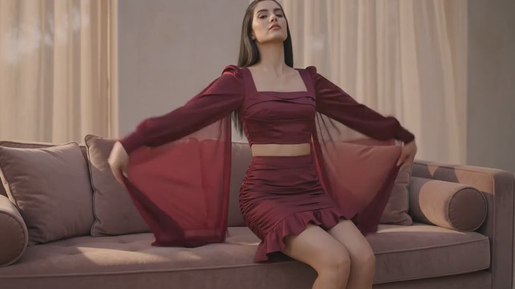 Woman in a burgundy outfit standing in a concrete architectural setting
